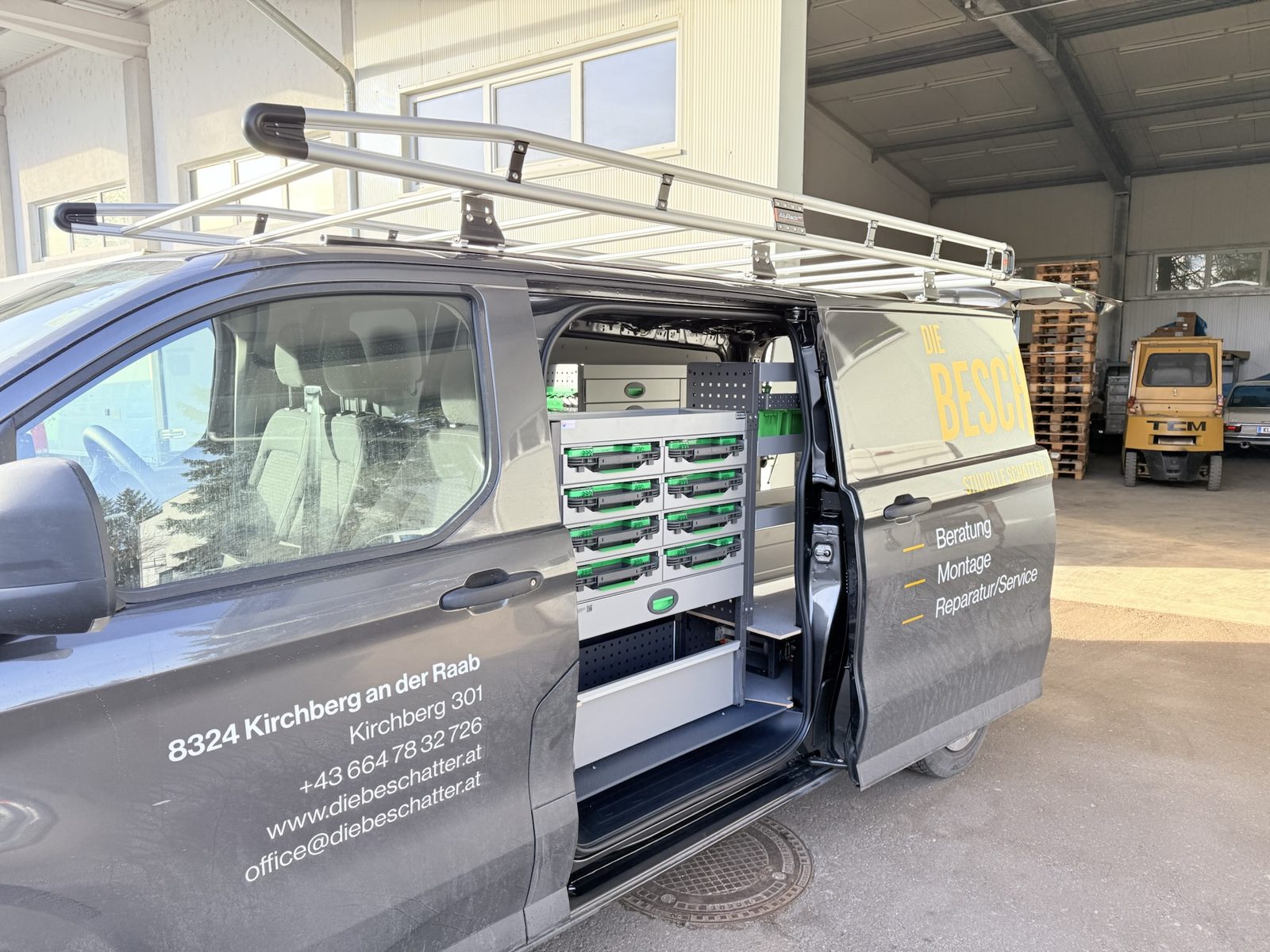 Dunkler Transporter eines Kunden mit System-Edström-Einrichtung und Firmenbeschriftung